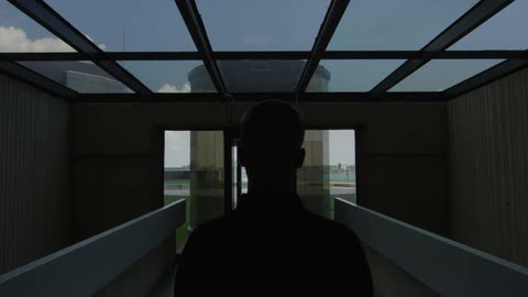 A man stands in a room with a glass ceiling