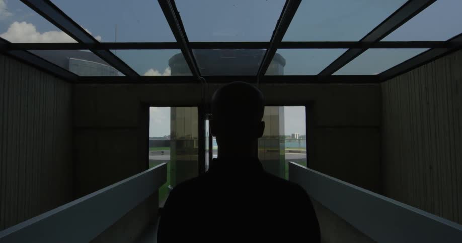A man stands in a room with a glass ceiling