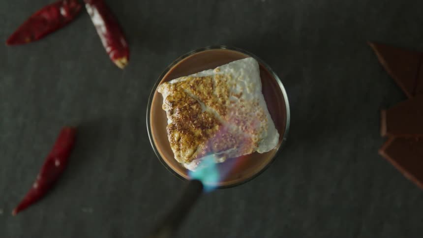 Small torch burns the top of a marshmallow black