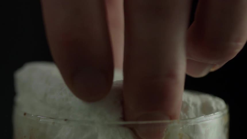 A person drops a marshmallow into a glass