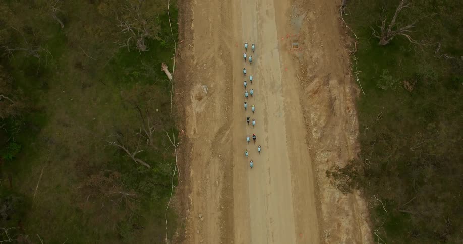 Bicyclists ride on a dirt road