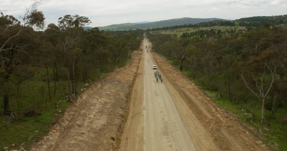 Bicyclists ride on a dirt road