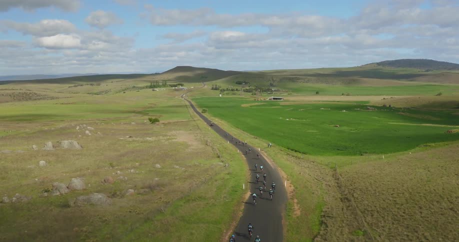 People are riding bicycles racing down the winding road
