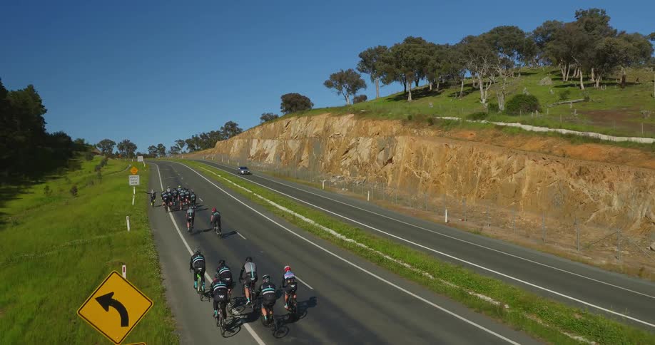 Bicyclists ride up a road
