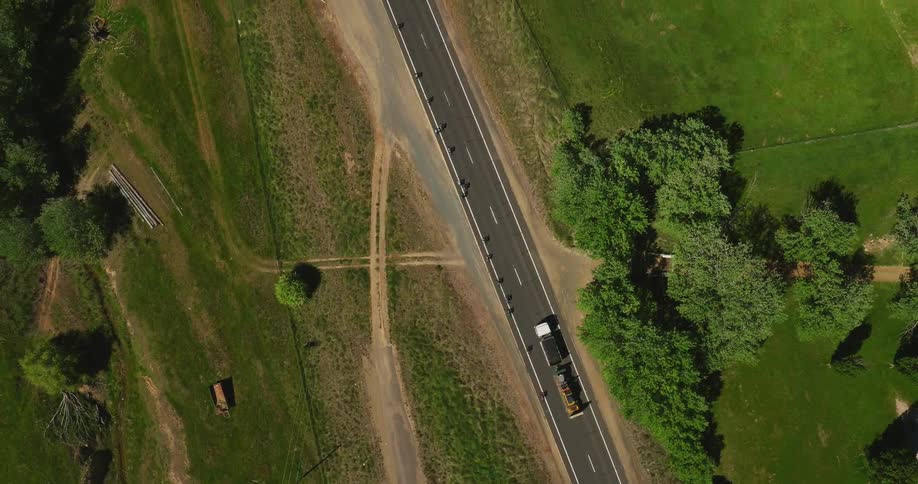 A large truck passes a line of cyclists