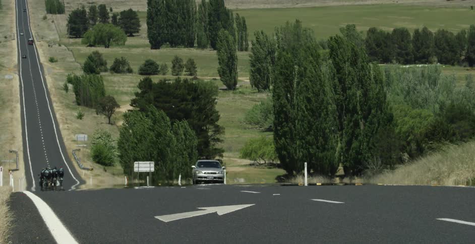 A silver car drives down the road