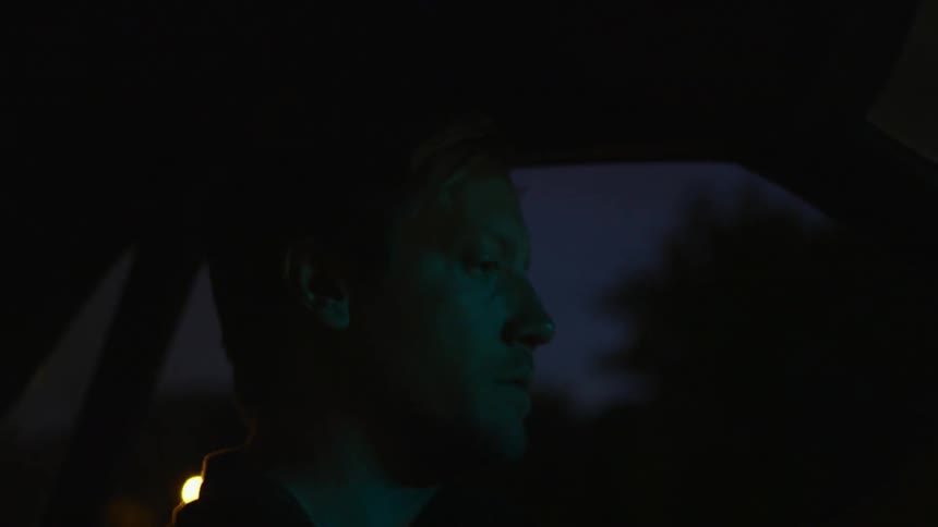 A man is driving a car at night