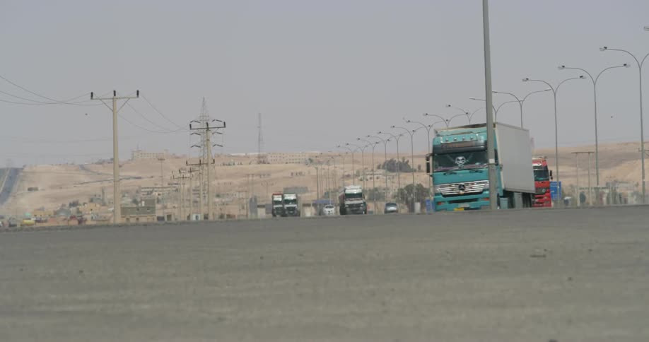 Trucks are traveling over the road on a cloudy day