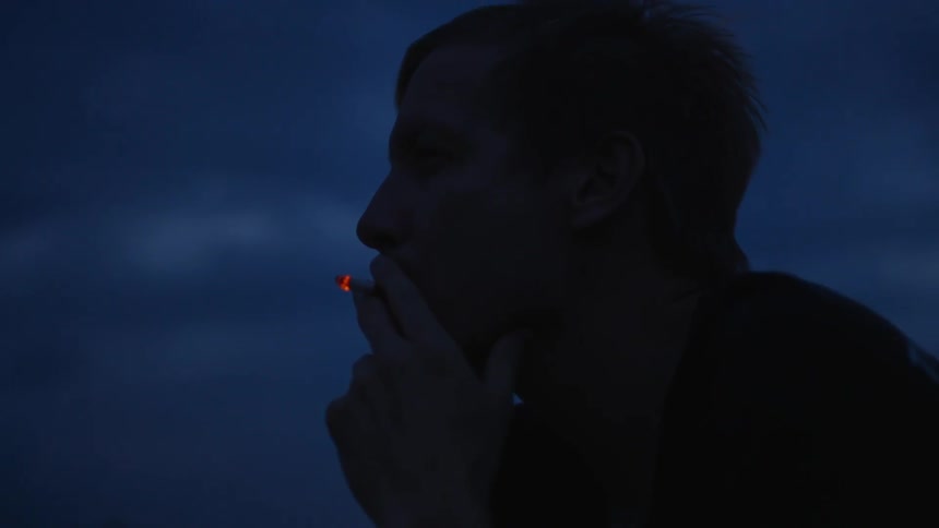 Man smoking a cigarette outside at night