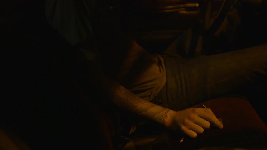 A person is sitting down holding something in their hand