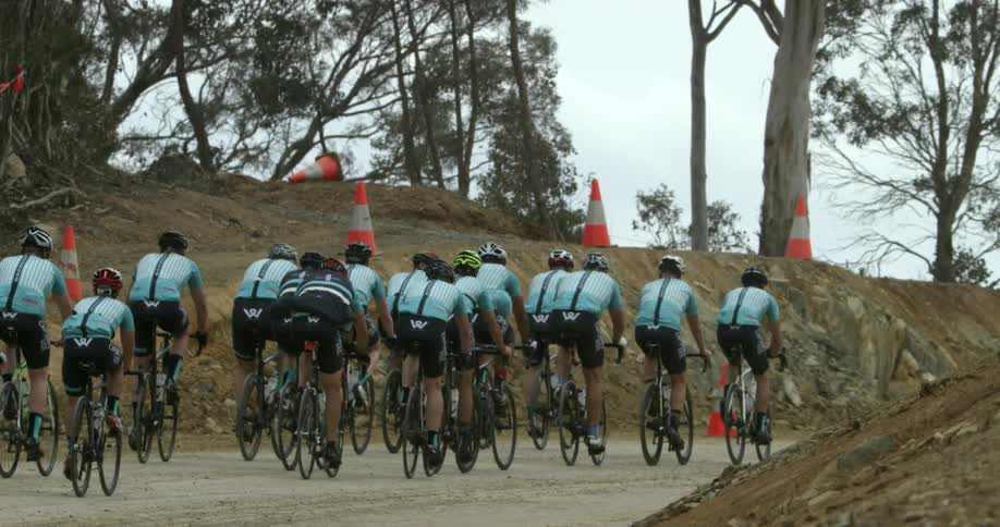 Bicyclists ride on a rural dirt road