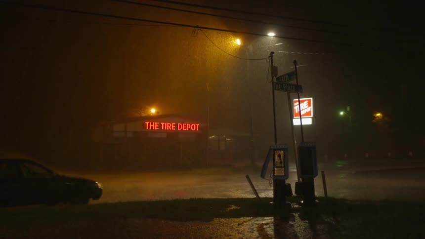 A car drives through a downpour