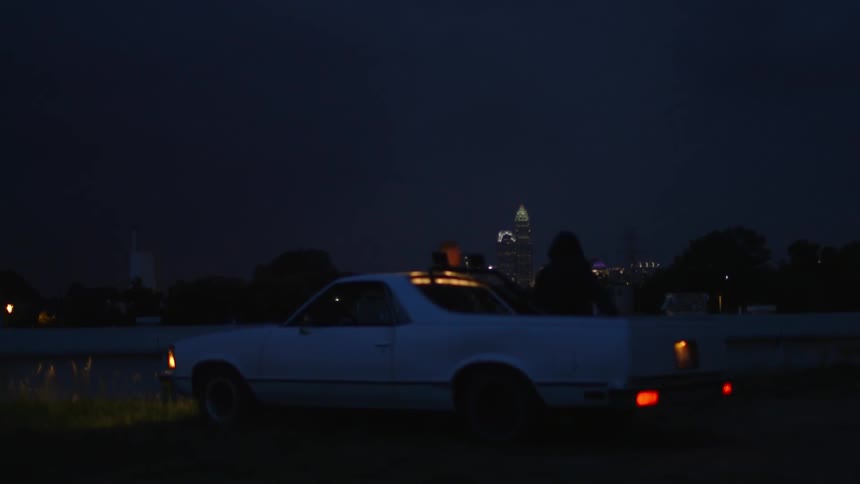 A car sits parked while running as it storms at night