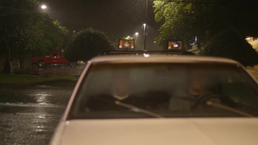 A man pulls his car to a stop in the rain
