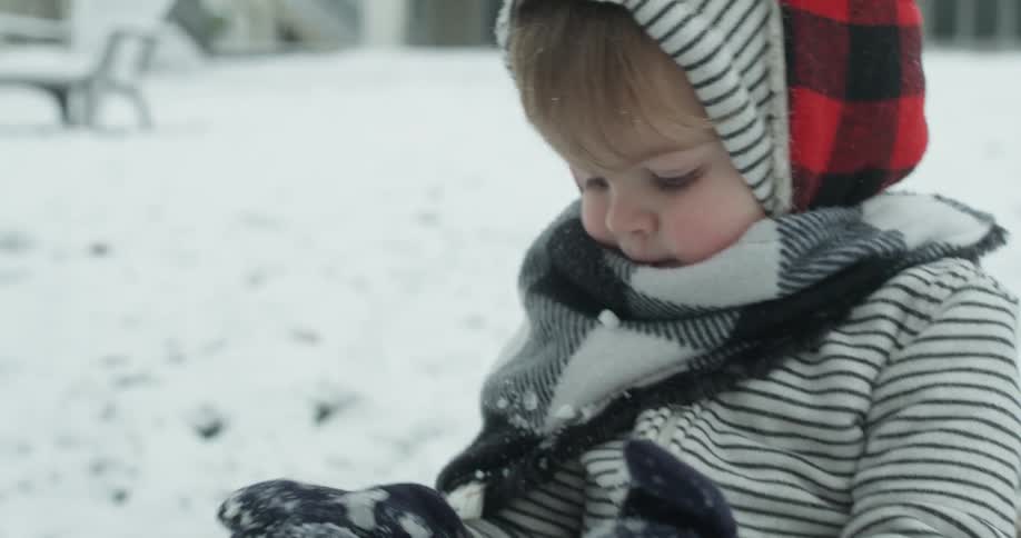 A young boy plays in the snow