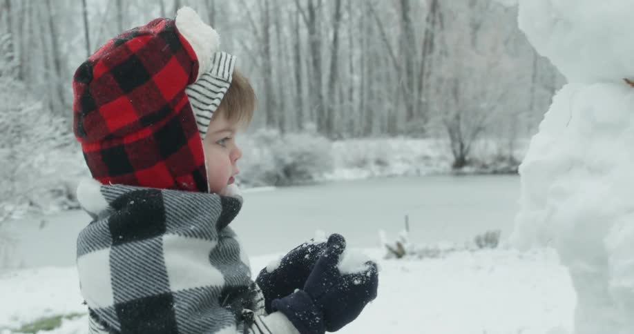 A young child plays in the snow