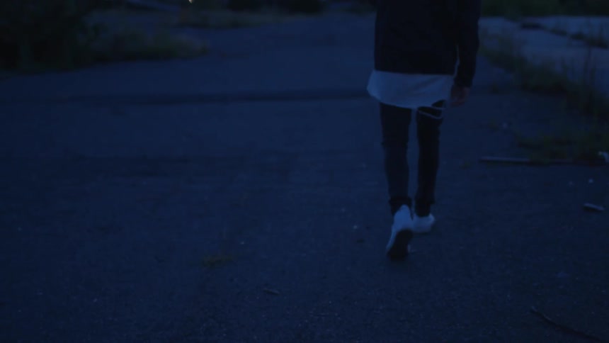 A person walks down the sidewalk at sunset
