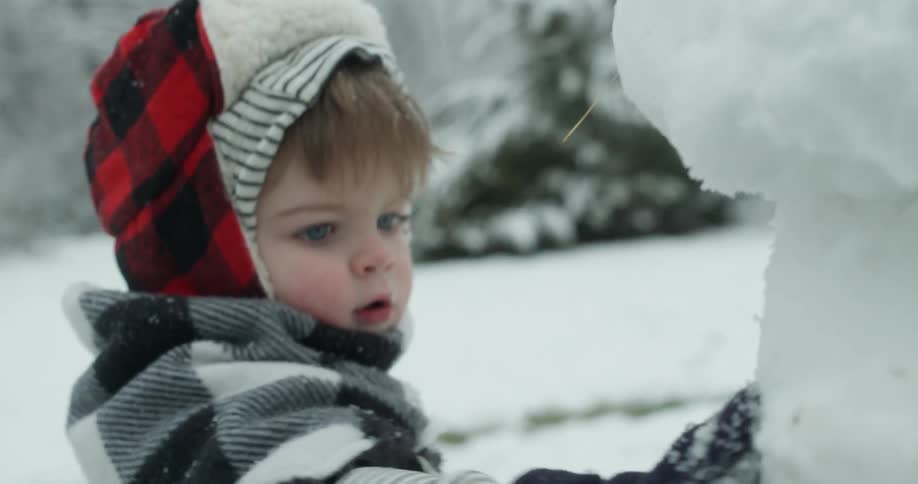 A young child plays in the snow