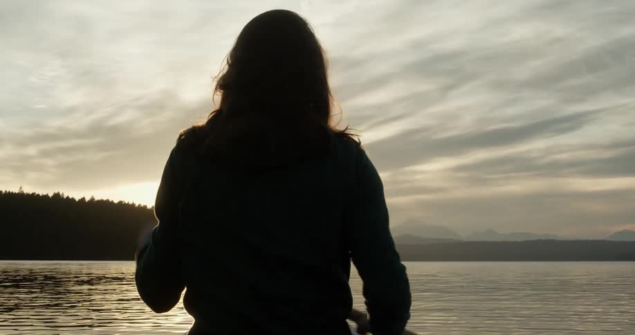 A woman paddles a boat on the water