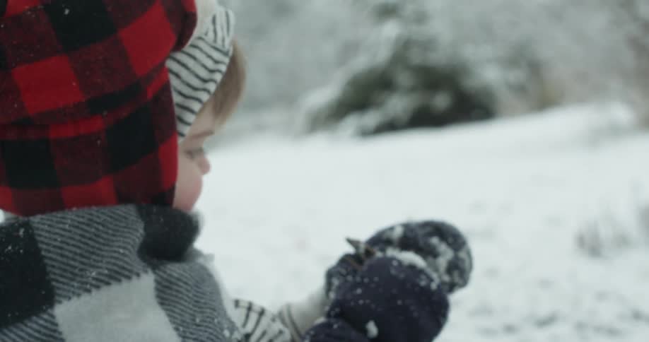 A young child is building a snowman