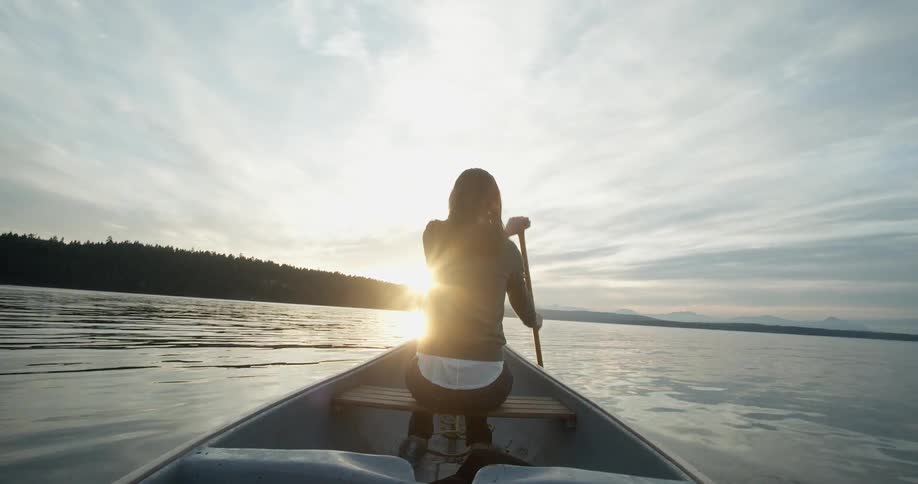 A woman paddles through a river