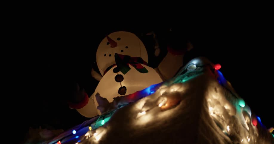 An inflatable snowman with lights sets on top of a platform