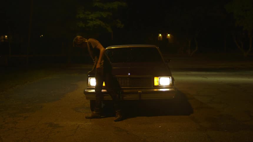 A man walks around a car