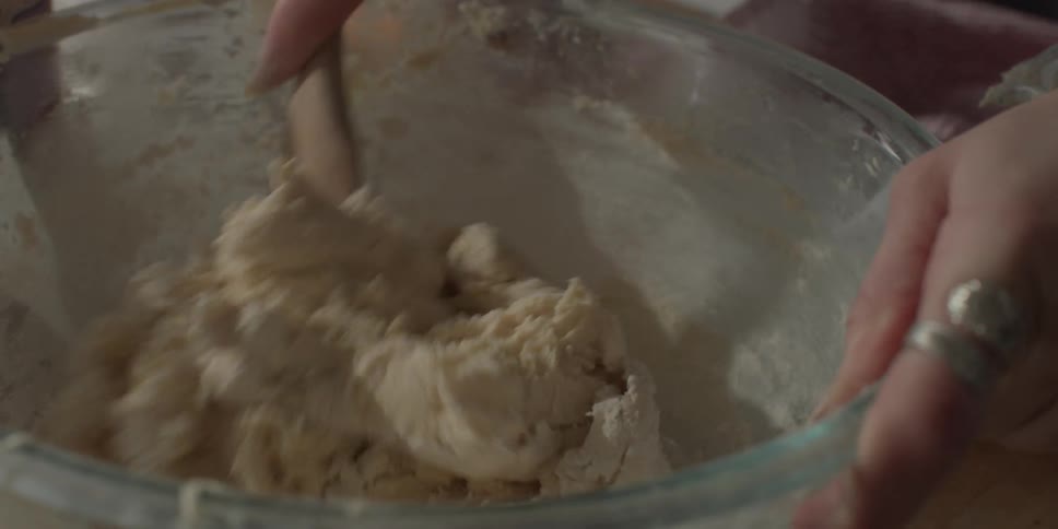 A woman mixes cookie dough in a bowl