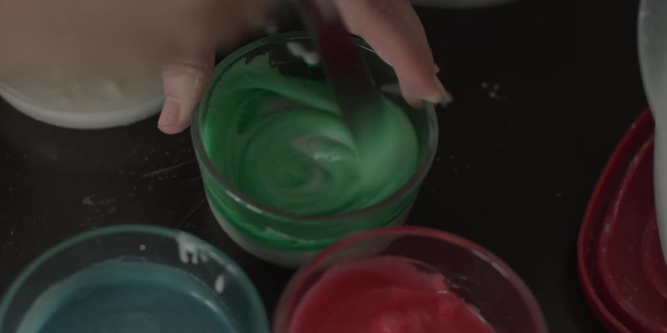 Woman mixes food coloring into icing