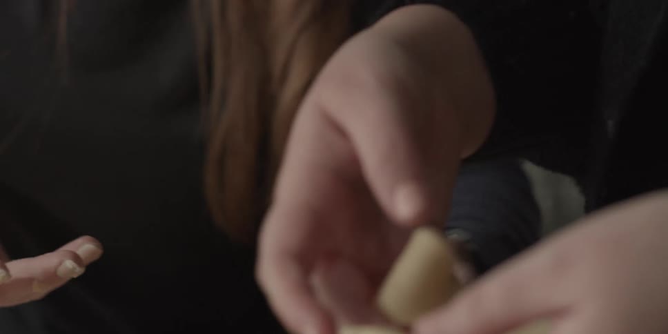 Woman laughs as another holds some dough