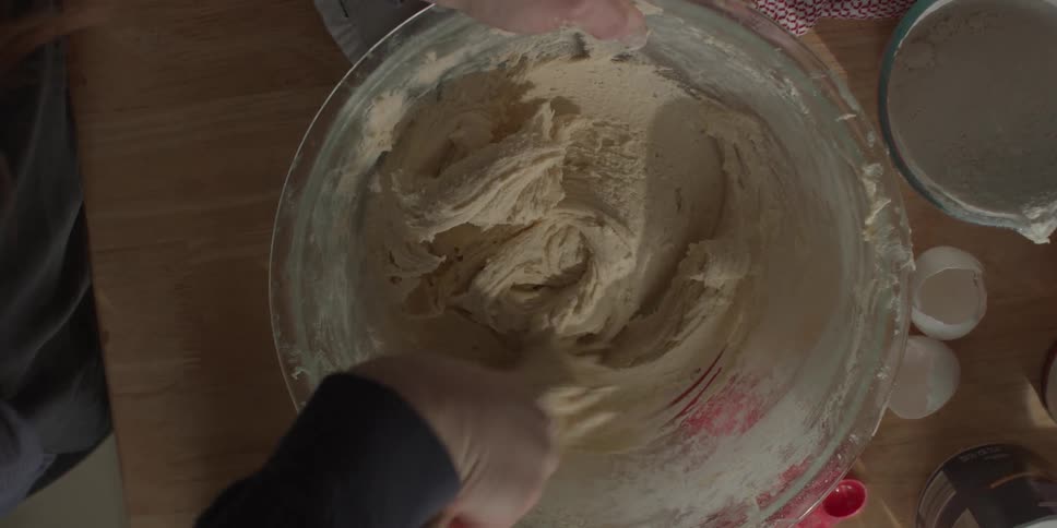A person is mixing batter in a large bowl