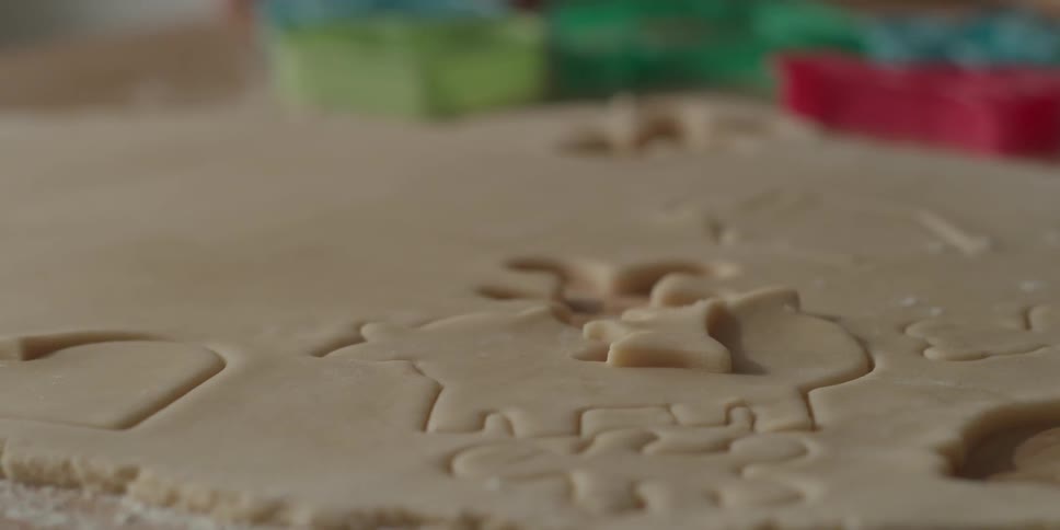 Someone is using a cookie cutter on dough