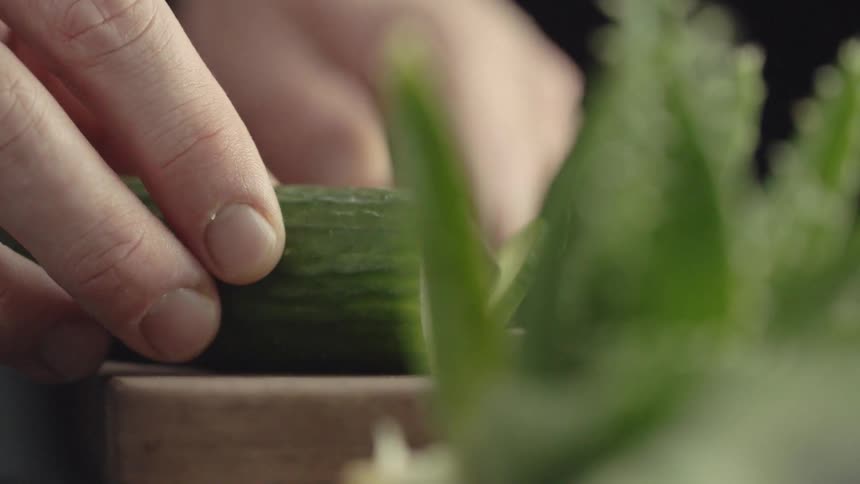 Someone is slicing a cucumber