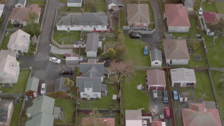 Cars parked in a street as other cars travel down a street