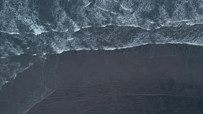 Frothy waves roll into a beach