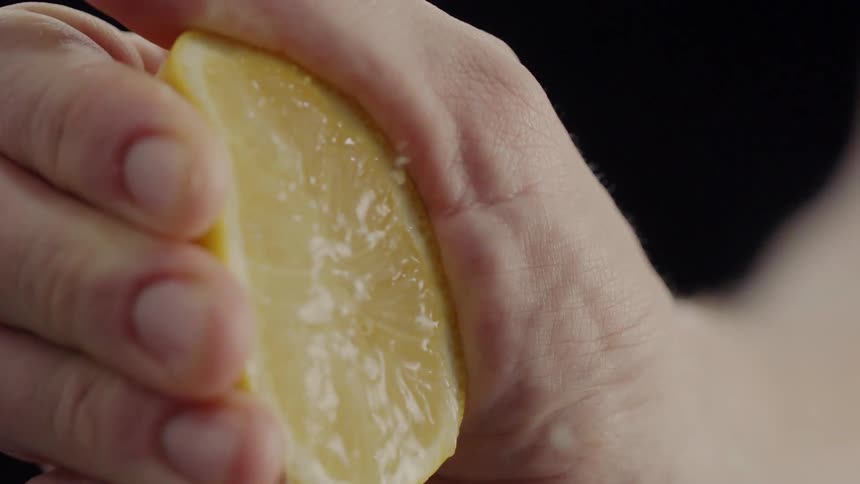 A person squeezes a lemon