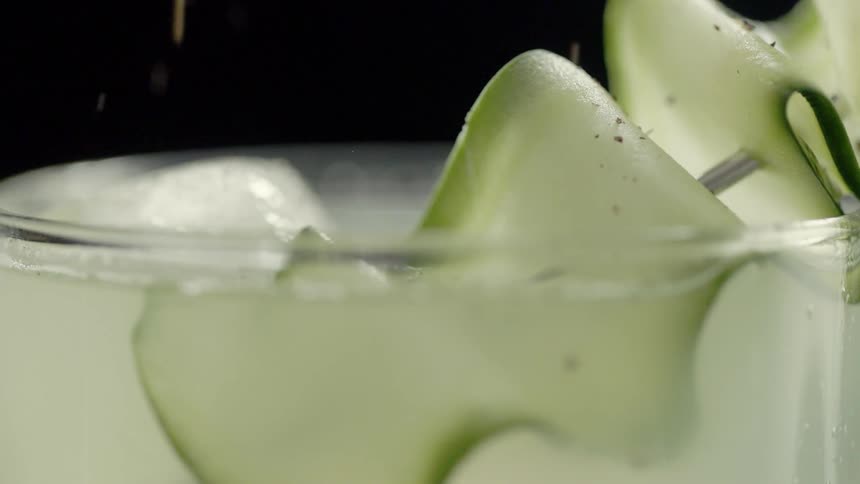 Spices are sprinkled onto a garnished cocktail