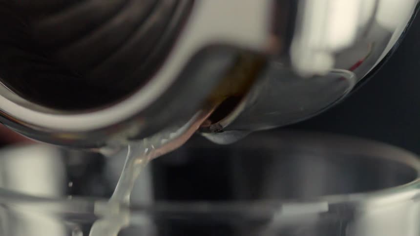 Liquid is poured from a canister into a glass