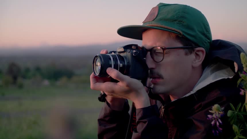 A man takes a photograph outside