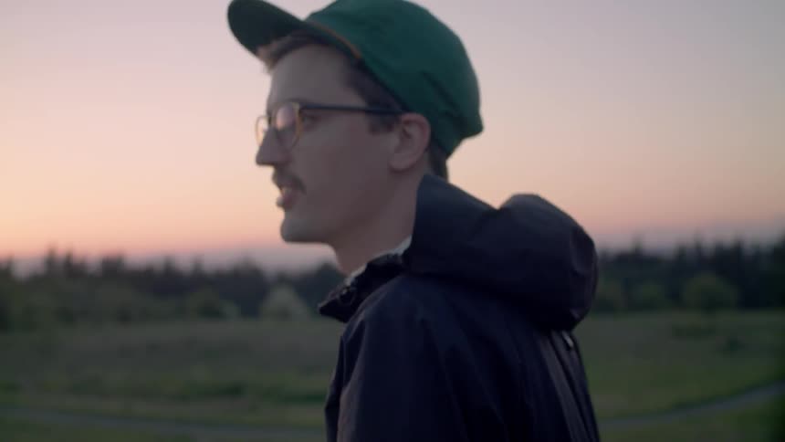 A man wearing glasses walks while talking