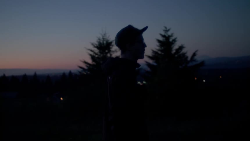 A man walks outside at dusk