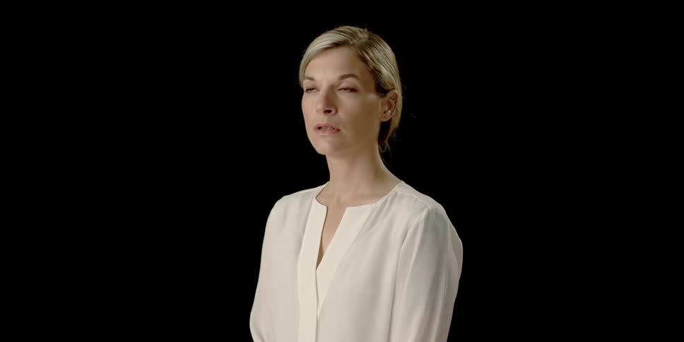 A woman is posing for a photograph wearing a white blouse
