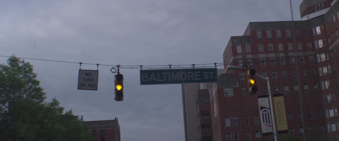 Driving under a yellow stop light labeled baltimore st