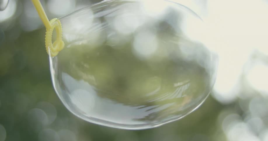 A person is blowing bubbles outside
