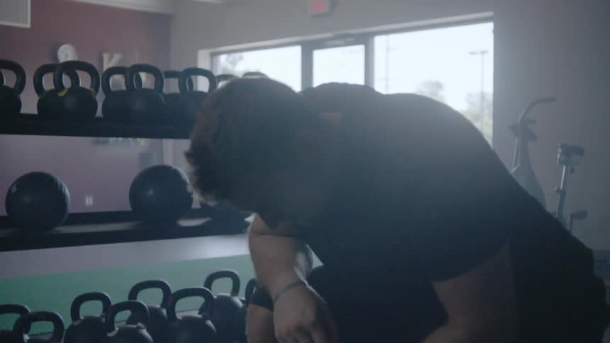 Man throws a weight ball in a gym