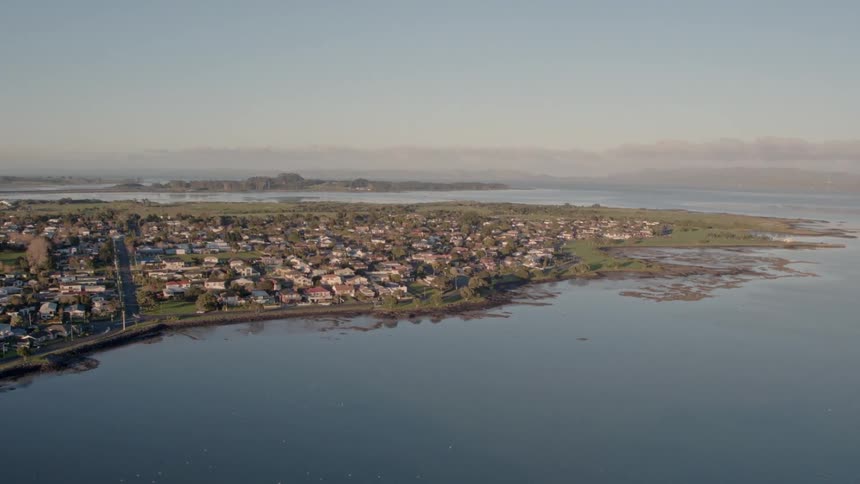 A large body of water surrounds a small town