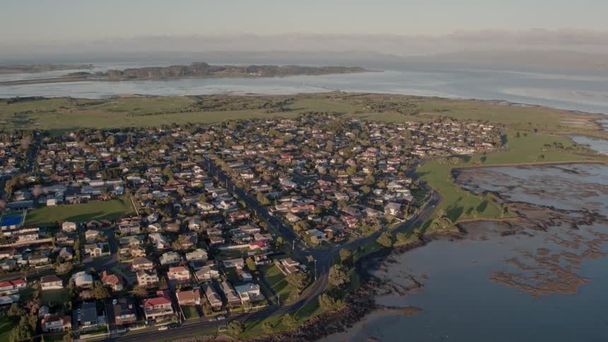 A small town surrounded by water is filmed by a drone