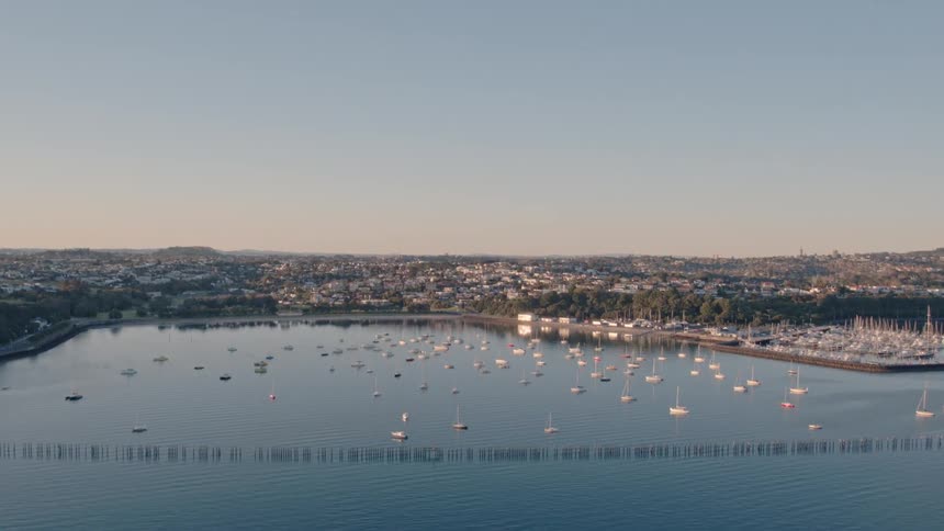 Boats float on a city lake at sunset