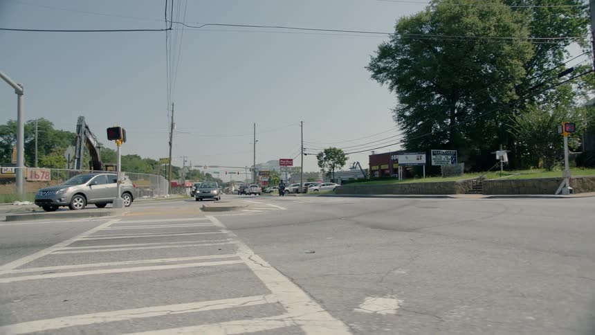 A man in a scooter drives past the intersection