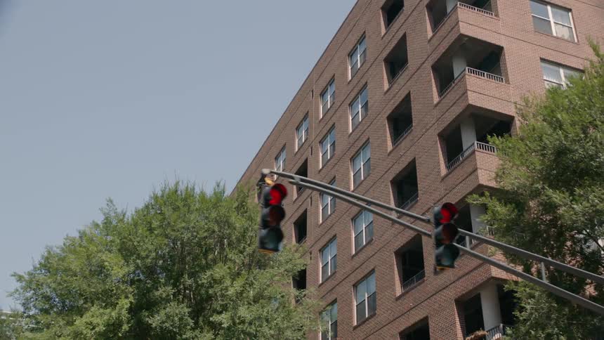 An apartment building is being filmed from a passing car